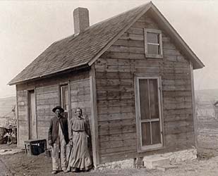 Antique photo of an African American homesteader couple.