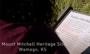 Person viewed from behind looking at a historic Underground Railroad information sign posted in the ground